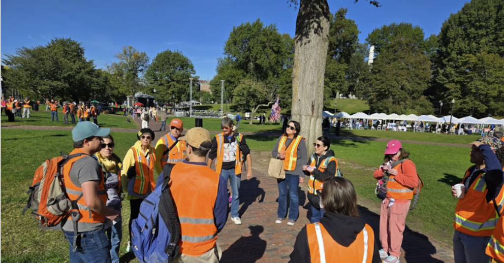 a group of people wearing safety vests in a public park